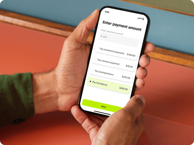 Hands holding a phone showing a MoneyMe payment screen