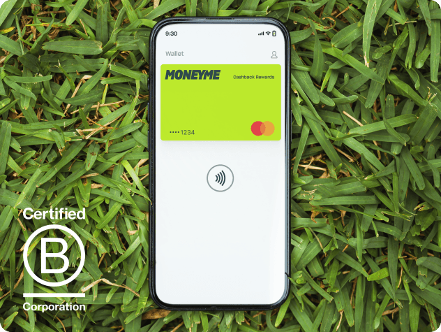 Phone on grass showing MoneyMe wallet app with B Corp Certified logo